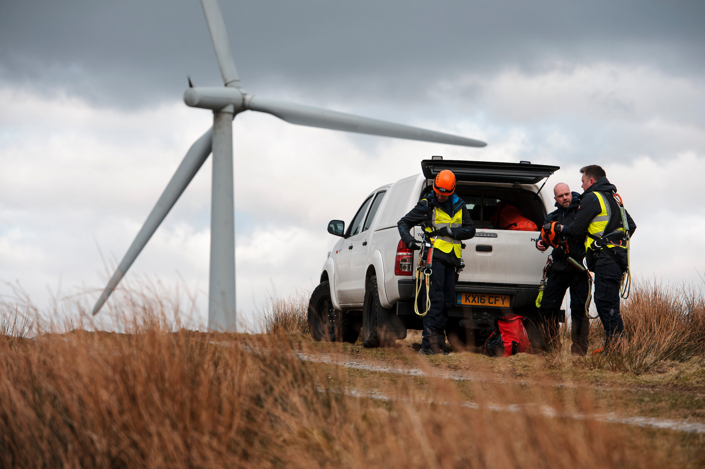 Wind turbine maintenance crew preparing near their vehicle .